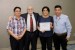Dr. Nagib Callaos, General Chair, giving Prof. Romel Tintin, Mr. Patricio Altamirano, and Mrs. Carmen Chávez the best paper award certificate of the session "Human, Information Systems and Software Engineering." The title of the awarded paper is "Could e-Government Development Reduce Corruption in South America?."